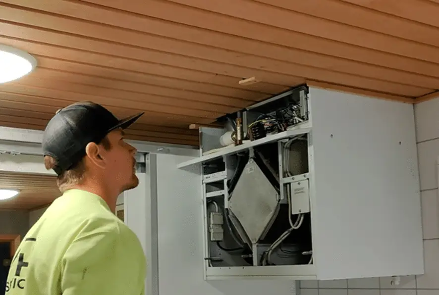 Paigaldaja hooldab kapis olevat ventilatsiooniseadet